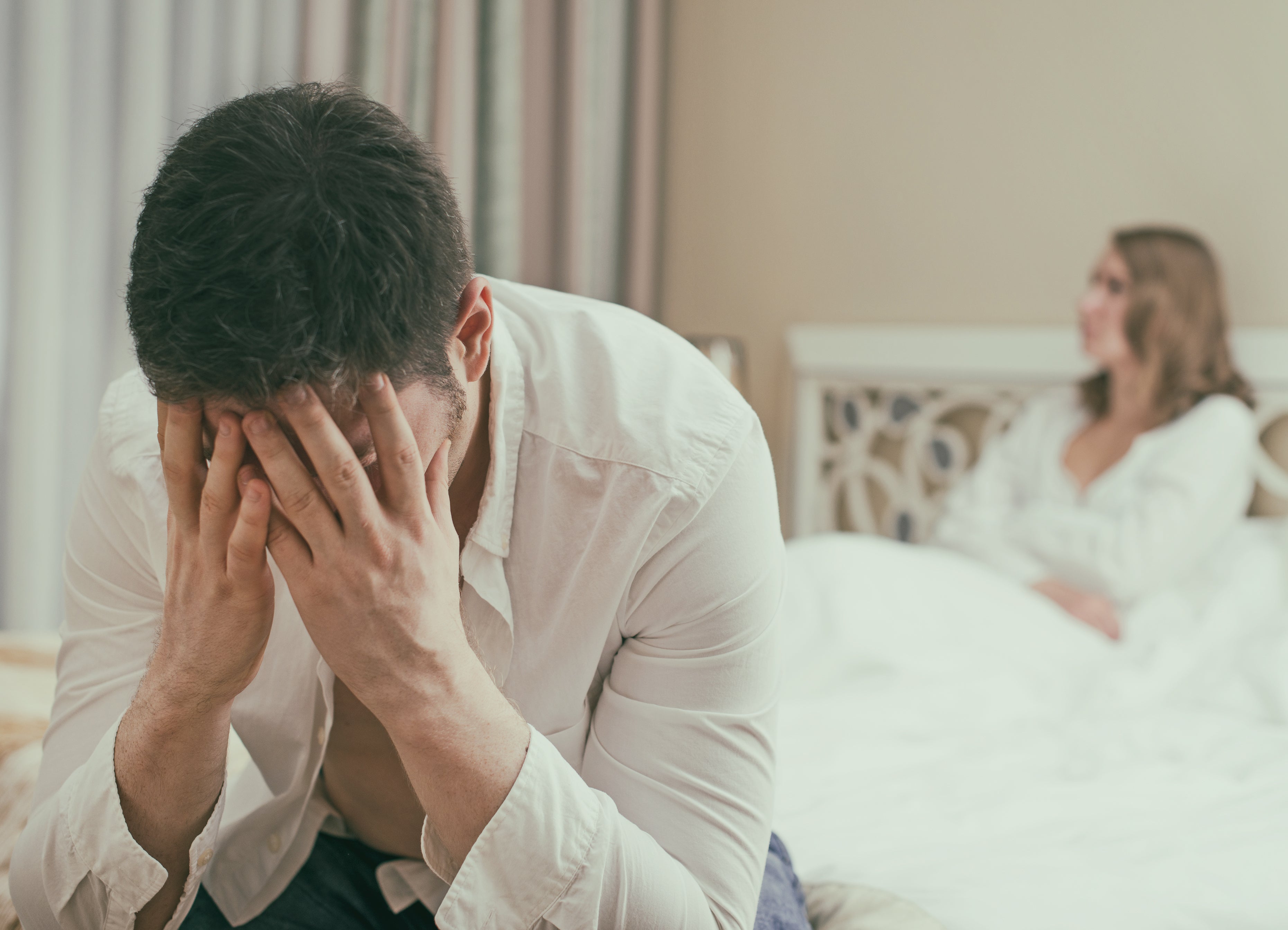Mann und Frau sitzen im Bett und sind unzufrieden
